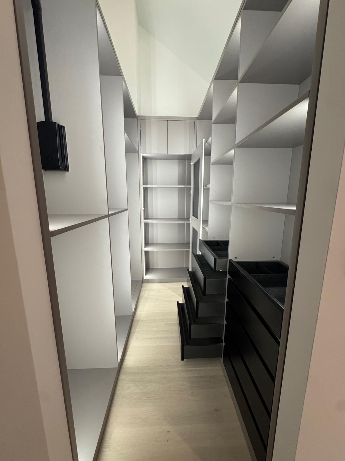 Couloir de dressing, colonnes blanches et tiroirs noirs
