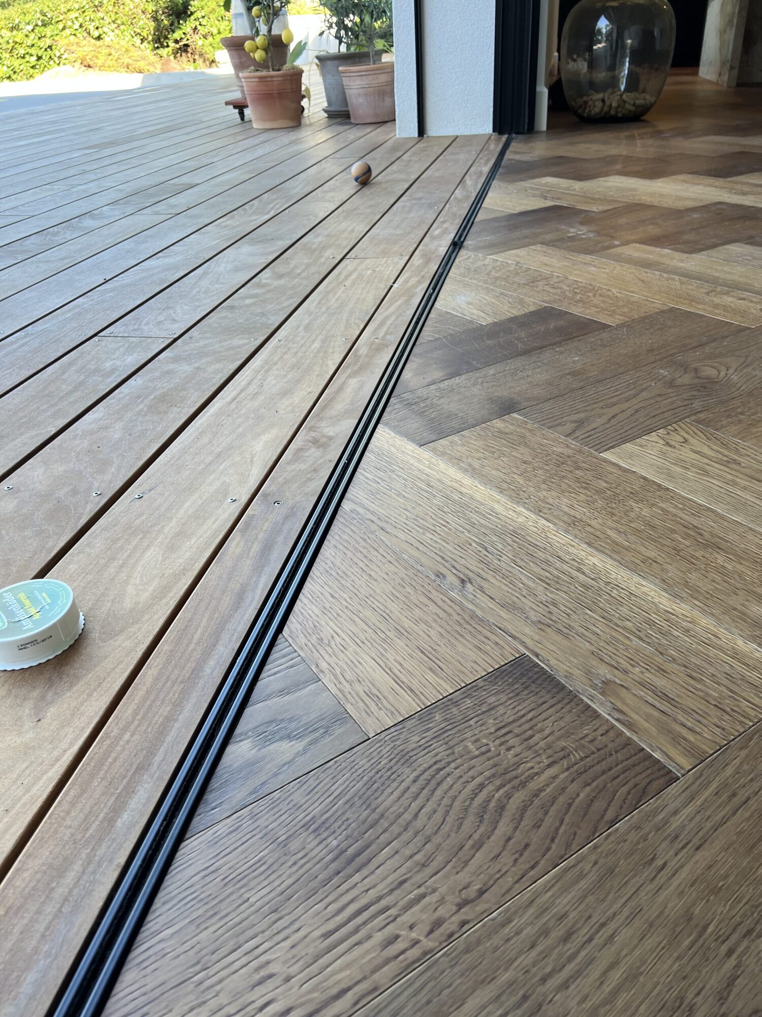 Raccord entre terrasse extérieure et parquet chevrons intérieur