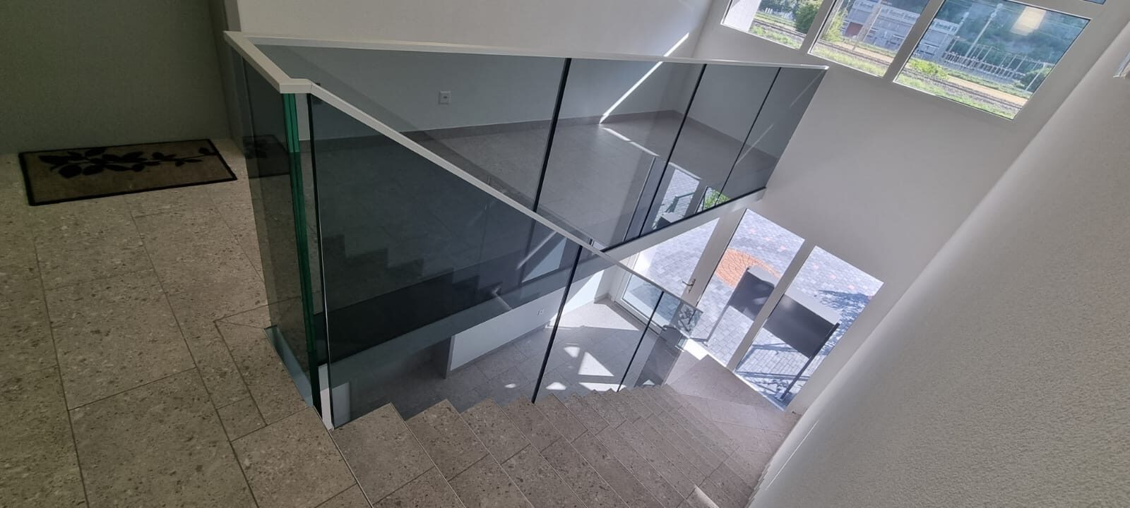 Vue plongeante sur un escalier avec garde-corps en verre