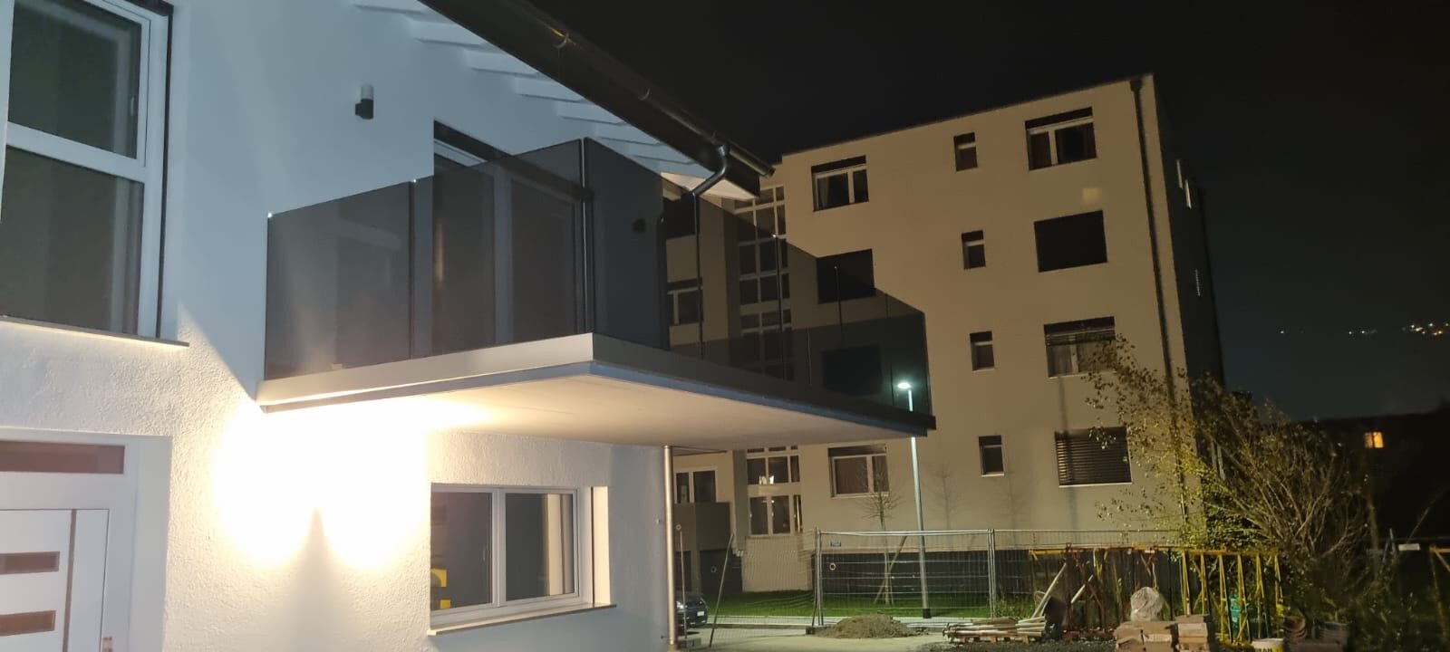 Balcon éclairé de nuit avec garde-corps en verre