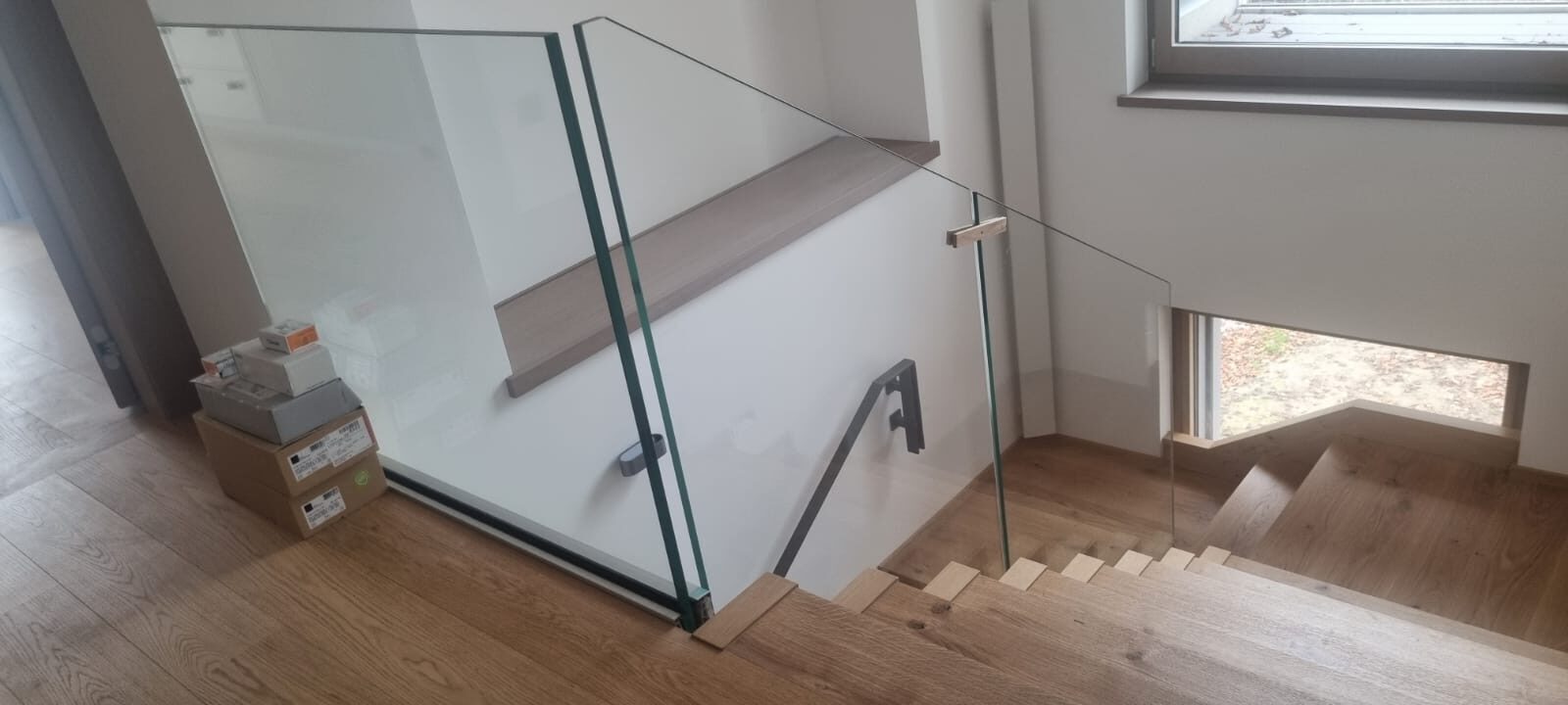 Garde-corps en verre le long d'un escalier en bois