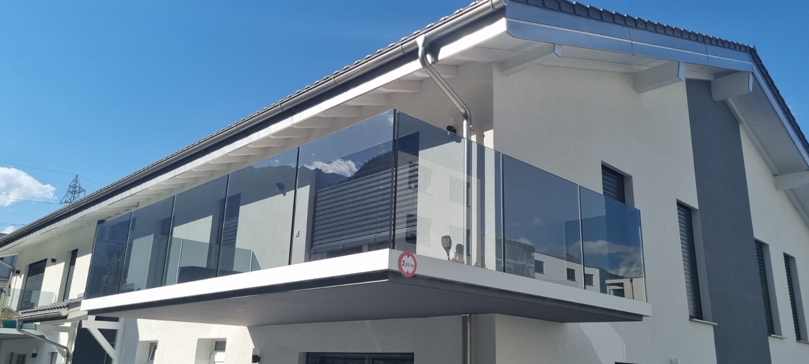 Balcon avec garde-corps en verre sous un ciel bleu
